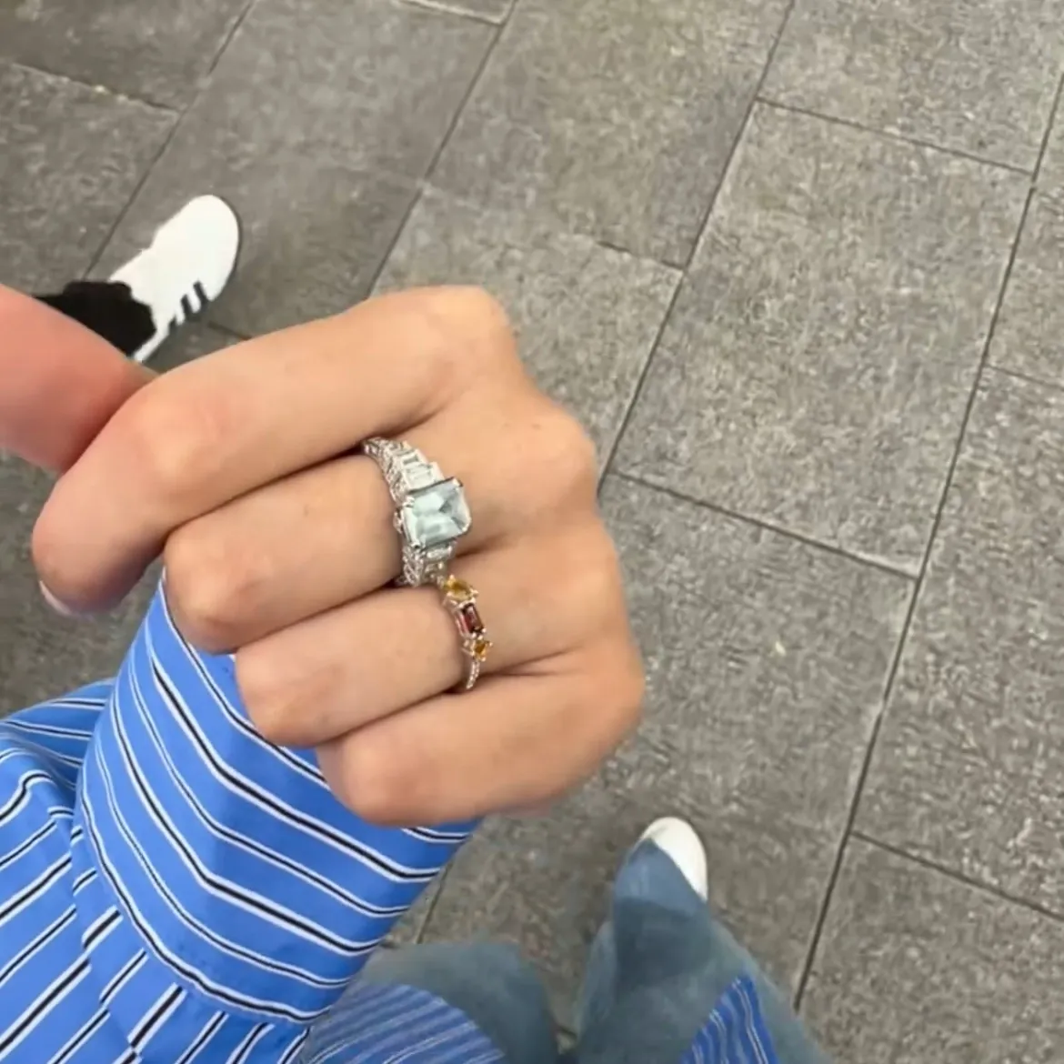 two rings on a hand with gemstones and diamonds